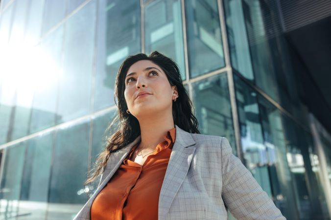 Self-confident female entrepreneur standing alone outside her workplace