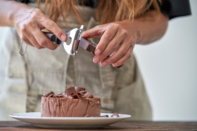 Chef decorating chocolate cake with shavings