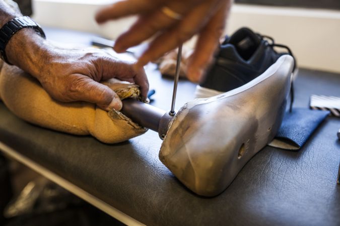 crop man fixing a prosthesis in a workshop