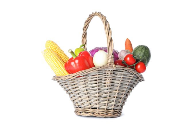 Wicker basket with vegetables isolated on plain background