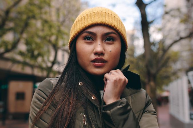 Close-up of young Asian woman in yellow beanie
