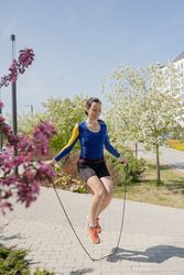 Young woman jumping rope in the park on a sunny day