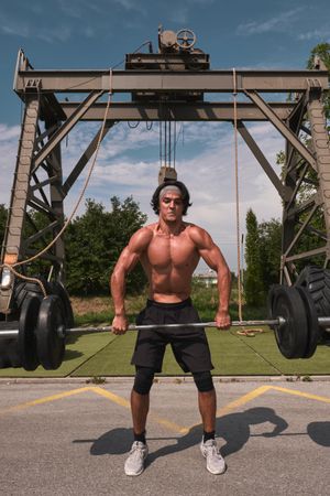 man with barbell in outdoor gym