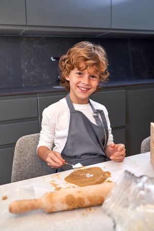 Cheerful boy preparing cookie dough