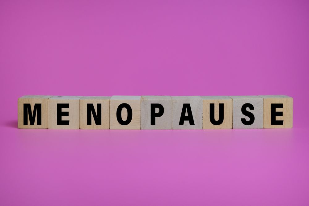 menopause words text on wooden blocks isolated on pink background