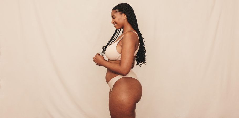 Side view of woman with natural curves and long hair in body positive photoshoot