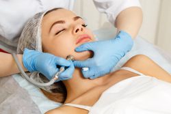 Woman having facial beauty treatment with machine on her jaw