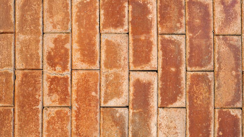 Orange brick wall with weathered texture and rustic vertical pattern