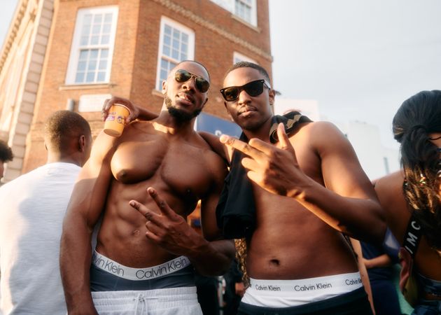 London, England, United Kingdom - August 27, 2022: Two shirtless male friends outside at Carnival