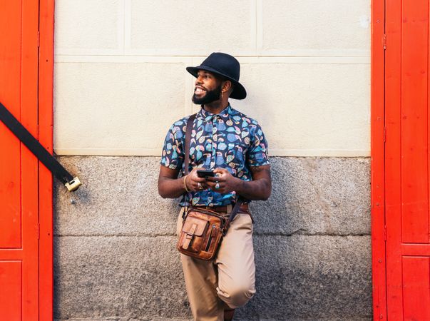 Stylish Black man using smartphone outdoors in the city