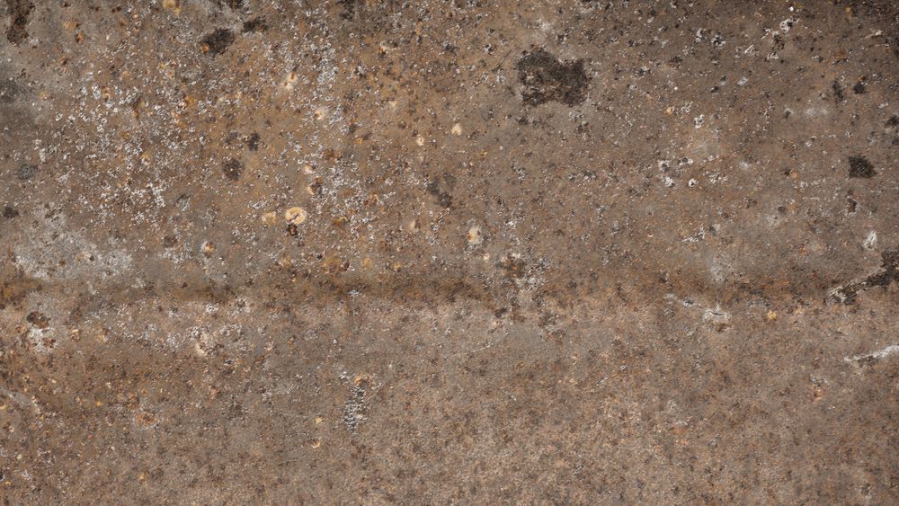 Old corroded steel plate with light rust and speckled industrial texture