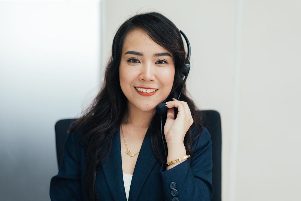 Asian woman in telephone headset at work