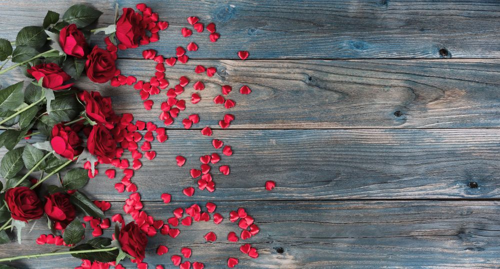 Valentine’s day with roses and small heart shapes on old blue wood