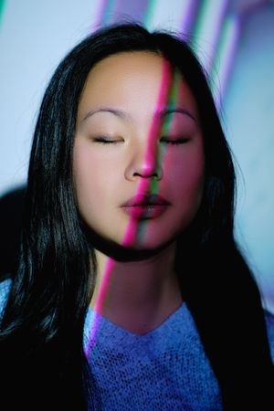 Asian woman with lights on face in studio
