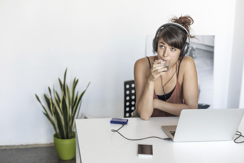 Female drinking from glass while sitting in home office