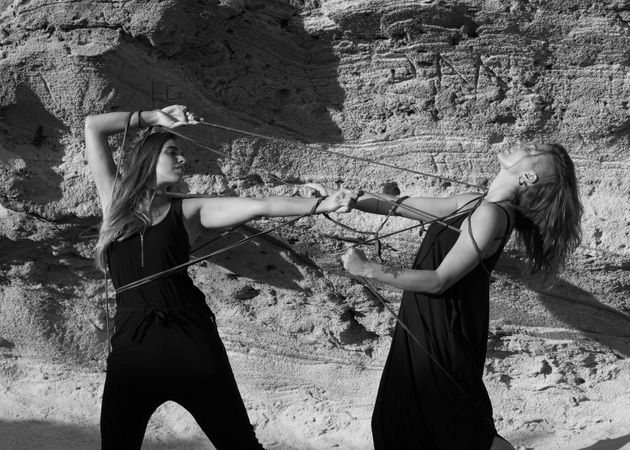 Women with textile dancing near stones
