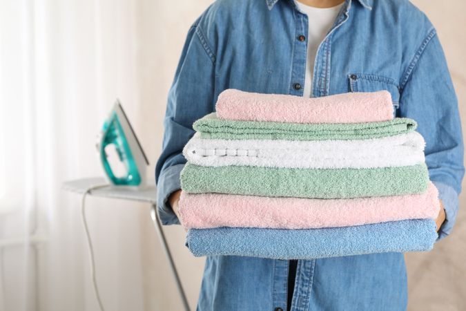 Young woman hold clean towels, close up and space for text