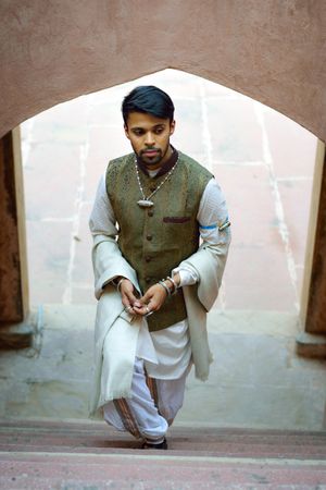 Man in gray kurta standing on concrete staircase