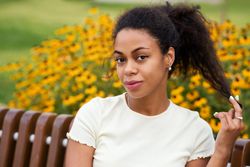 Portrait of Black female sitting on bench in front of flowers