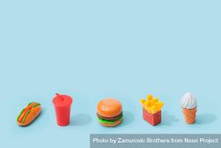 Plastic fast food items on baby blue background 43wRj4
