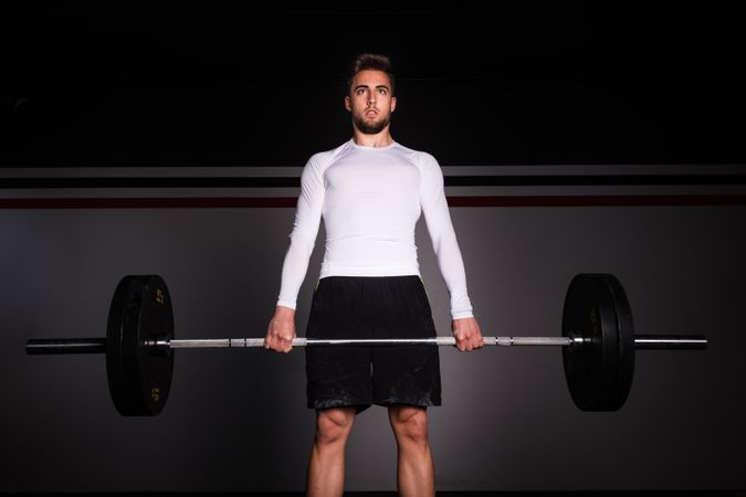 Man lifting barbell in gym