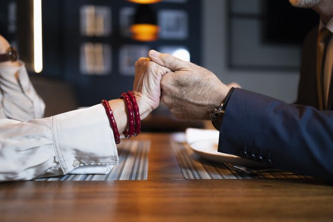 Close up of mature couple hands at restaurant table