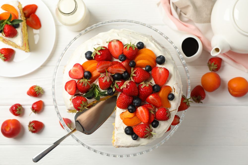 Composition with delicious berry cream cake on wooden table. Tasty dessert