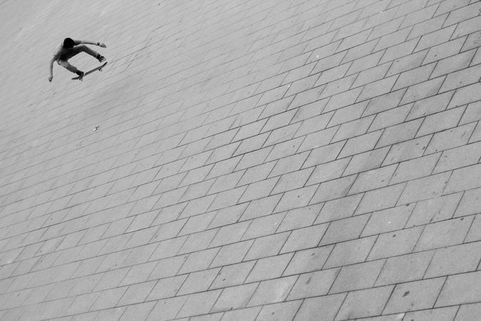 Grayscale photo of person skating outdoor