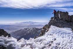 Tourist enjoying breathtaking view at snowy mountain top