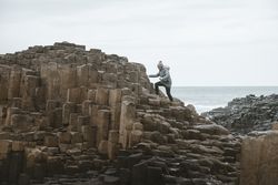 Female standing on cliff and contemplating
