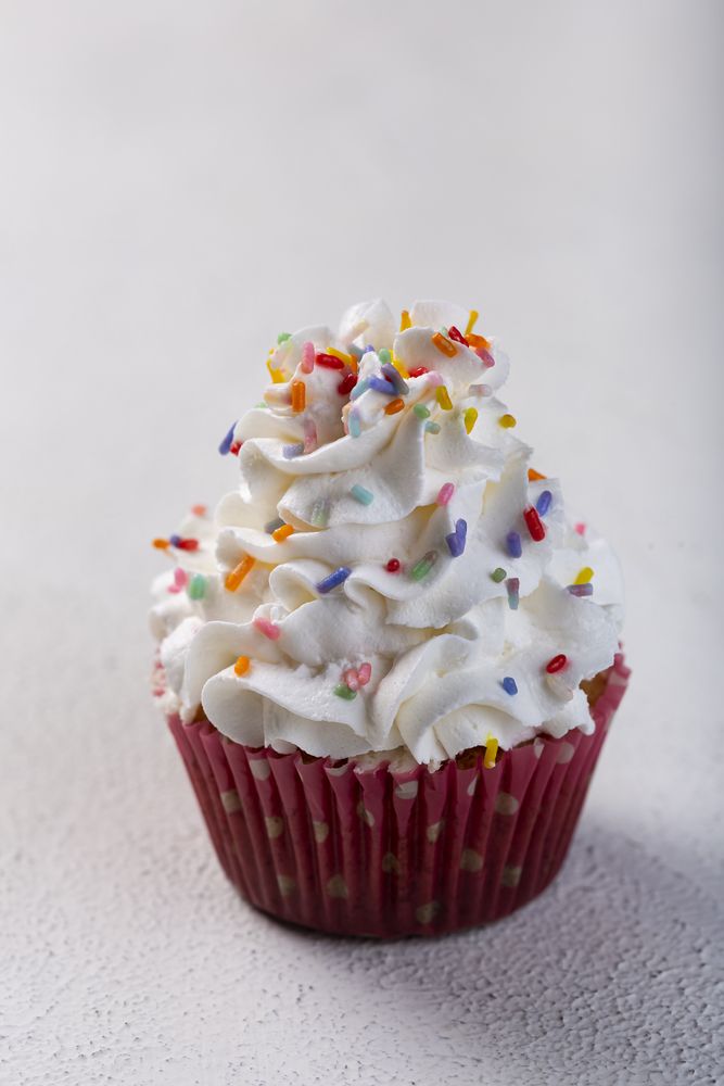 Tasty party cupcakes on the table. Cupcakes with whipped cream.
