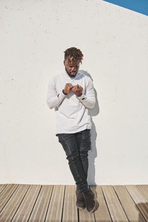 Stylish Black man looking at hands
