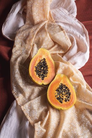 Ripe papaya fruit halves on tablecloth