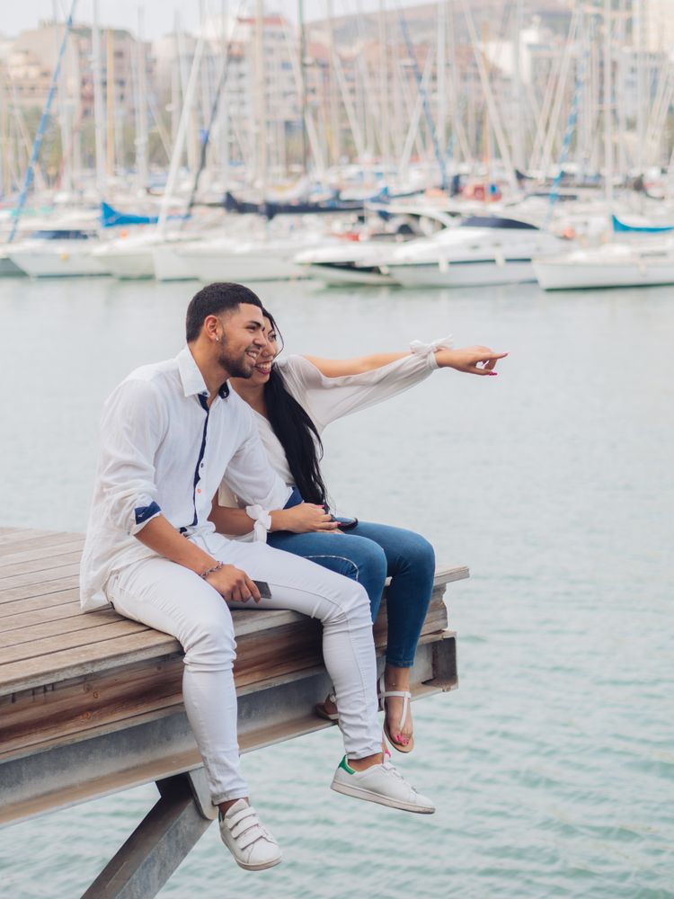 Man and woman sitting on dock with feet