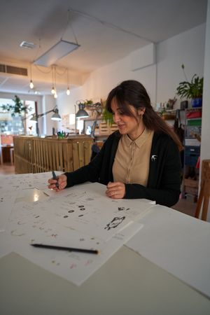 Female designer drawing jewelry sketches in studio
