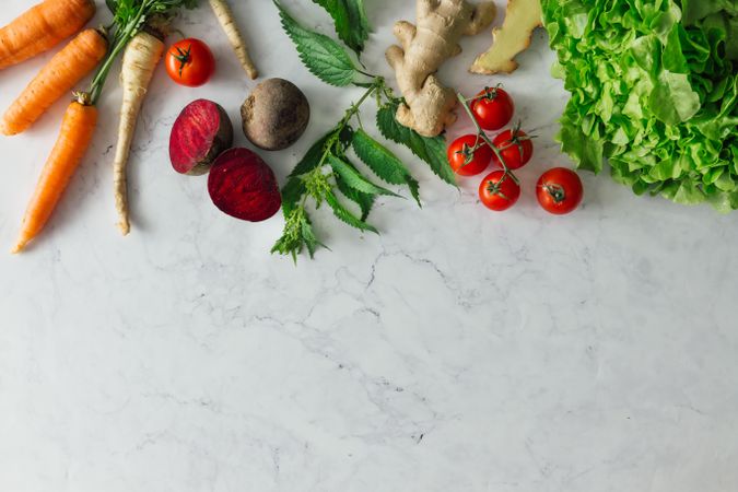 Fruits, vegetables and herbs on bright marble table background