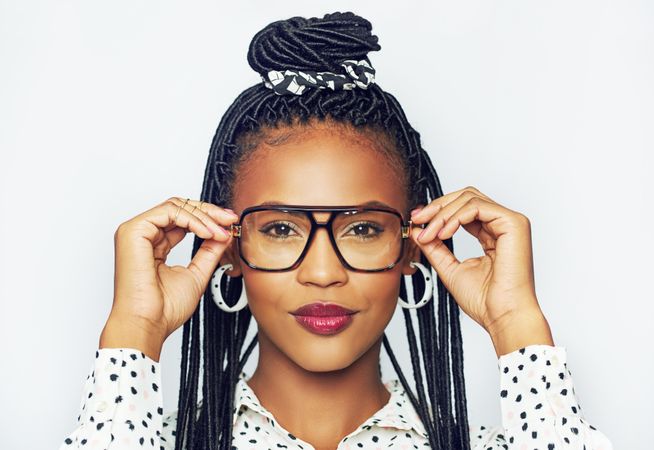 Studio portrait of serious woman wearing eyeglasses against a bright background