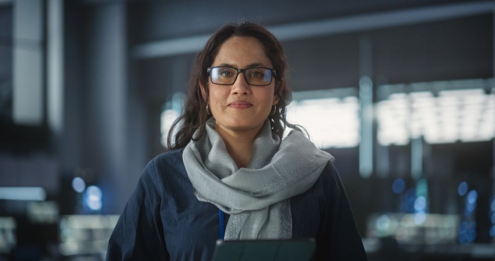 Portrait of a Happy Smiling Female Using Tablet Computer, Looking at Camera and Smiling.