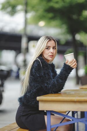 woman drinking coffee in street cafe