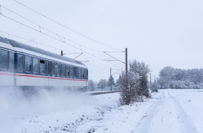 Passenger train passing through snowy fields in Germany