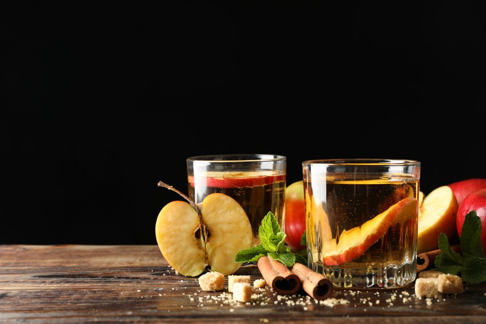 Composition with cider, sugar, cinnamon and apples on wooden table