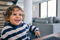 Cheerful boy sitting at table and smiling