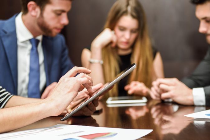 Corporate colleagues using digital tablet during a meeting