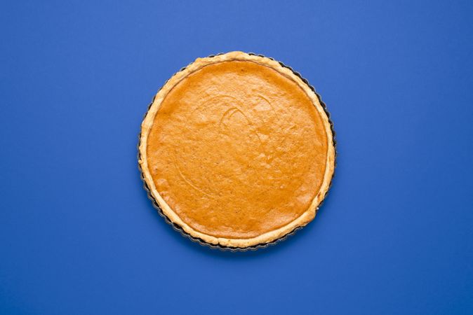 Pumpkin pie top view minimalist on a blue background