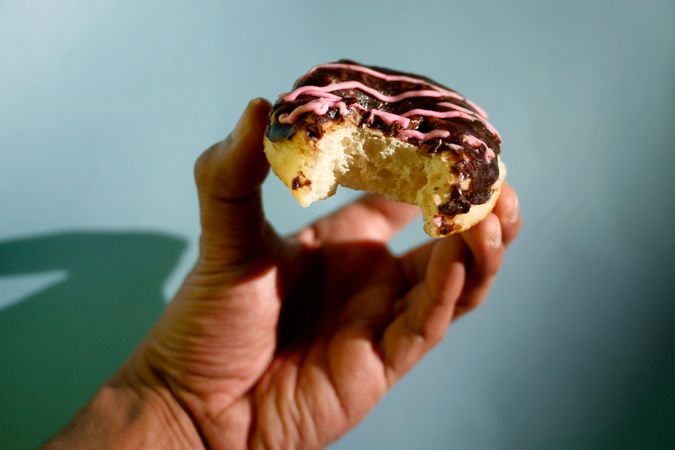 Side view of chocolate donut with bite