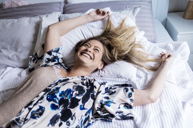 Portrait of a smiling adult woman lying on a bed
