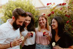 Group of cheerful friends clinking glasses at party