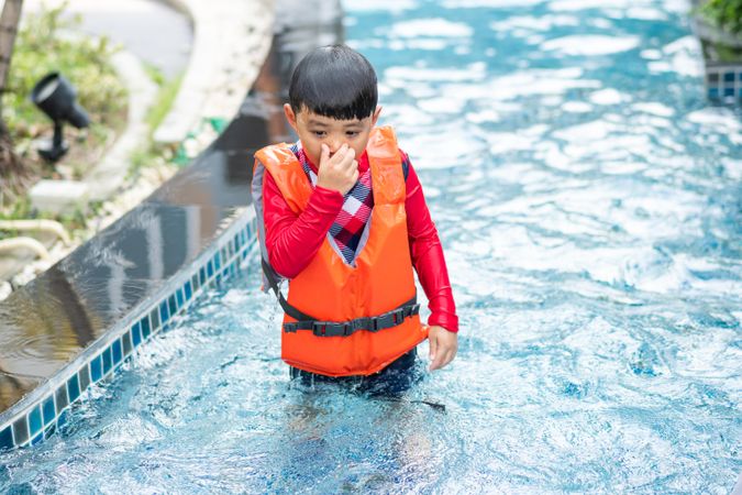 Boy holding his nose in swimming pool