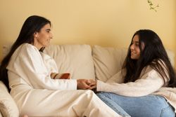 Mother and daughter smiling and holding hands looking each other. Happiness is homemade
