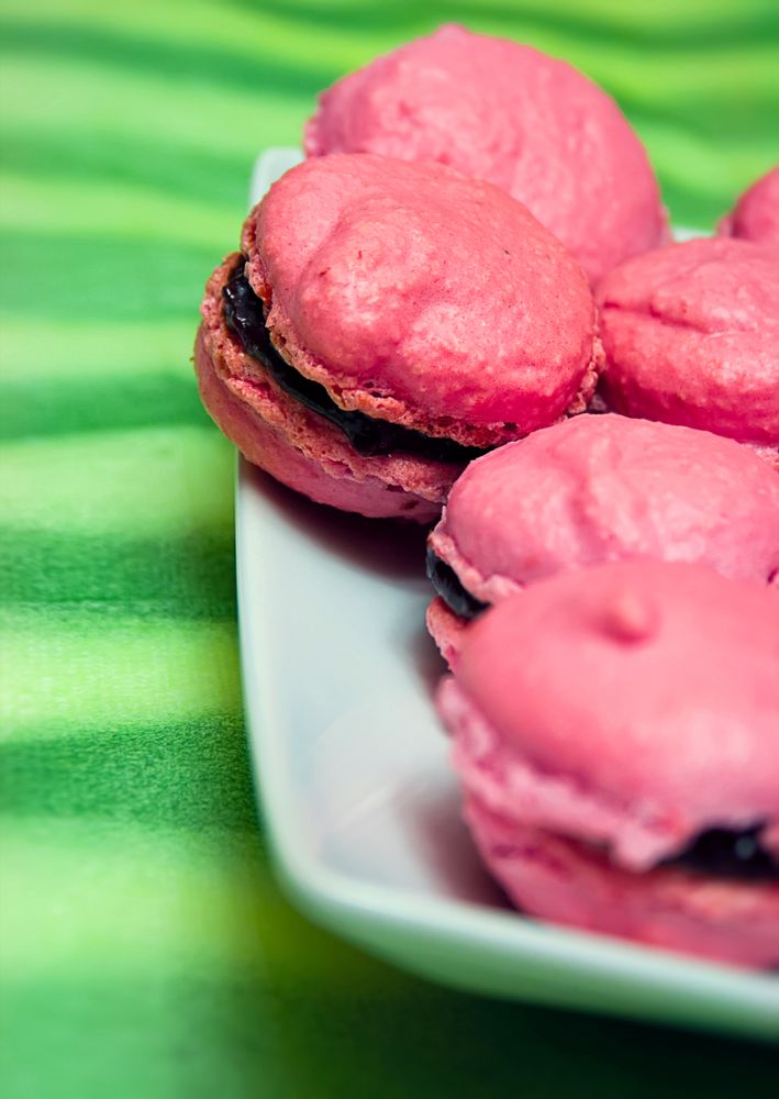 Pink macarons on green background.
